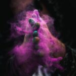 person with colored powders on hands