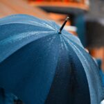 person holding umbrella while raining